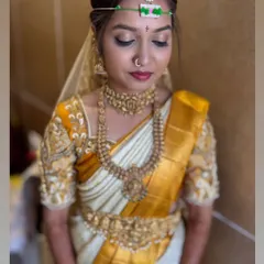 A beautiful Muhurtham look with soft golden eyeshadow and a deep red lip. The focus is on creating a divine, goddess-like appearance that is perfect for the wedding ceremony.