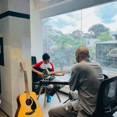 A student receives one-on-one guidance during a guitar lesson. Our small class sizes ensure every student gets the personalized attention they need to thrive.