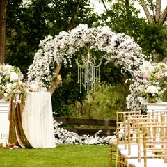 For this outdoor garden wedding, we created a lush floral arch using a cascade of white flowers. A crystal chandelier adds a touch of glamour, perfectly blending natural beauty with elegant design for a magical "I do" moment.