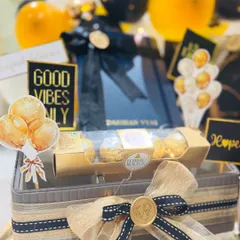 This shot highlights the thoughtful details, from the 'Good Vibes Only' tag to the carefully arranged sweets. Every element is chosen to inspire positivity and celebrate a new professional chapter.