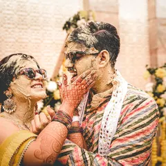 The Haldi ceremony is all about unrestrained joy, and we live for capturing it. This moment of the couple playfully smearing turmeric on each other, with genuine laughter and cool sunglasses, perfectly shows the fun and candid spirit we aim to freeze in time.