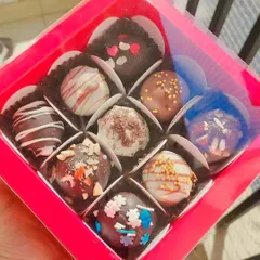 A box of nine of my assorted, handmade chocolate truffles. Each one is uniquely decorated with sprinkles, nuts, or chocolate drizzles. This is a budget-friendly yet decadent gift option.