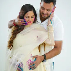 A sweet and tender moment amidst the fun of the Holi shoot. The partner gently holds the mother-to-be, their hands covered in color, creating a memory that is both playful and loving.
