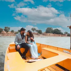 A beautiful shot of a couple on a boat in Gadisar Lake, Jaisalmer, with the historic architecture in the background.