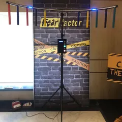 This is our 'Catch the Baton' or 'Fear Factor' reflex game, set up against a themed backdrop. It's a simple yet challenging game that can be enjoyed by both kids and adults.