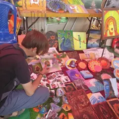 A visitor taking a closer look at my small stone paintings and other handcrafted items at my stall.