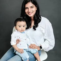 A beautiful mother and son portrait against a classic grey studio background. The clean, simple setup allows their connection and smiles to be the main focus of the photograph.