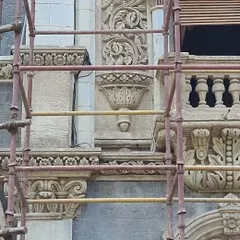 A close-up of the building's ornate stone carvings. Our primary challenge was to conceal the fixtures while ensuring the light would graze the surface perfectly to reveal these beautiful, intricate details.