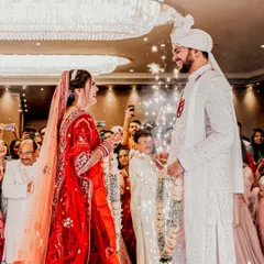 The Varmala exchange is a moment of playful excitement and acceptance. Here, the bride garlands the groom amidst a shower of sparklers, with their families cheering them on. It's a perfect capture of joy during a Hindu wedding.