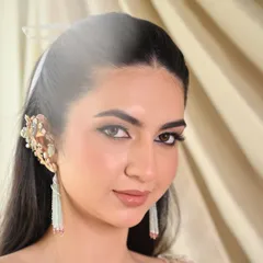 A close-up of the makeup and hair for this editorial shoot. The makeup is clean and sharp, with a defined winged liner, and the hair is kept sleek to complement the modern jewelry.