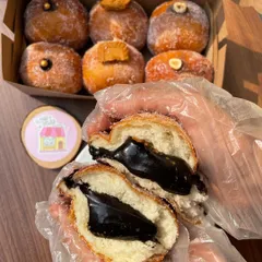A box of my assorted Italian stuffed donuts, also known as bomboloni. This one is cut open to show the rich, dark chocolate filling.