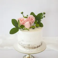 Simplicity wins with this semi-naked cake and fresh pink roses. The "less is more" frosting style allows a little of the cake to peek through, creating a lovely rustic texture.
