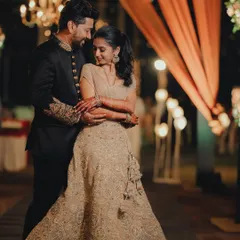 A romantic embrace between the couple, with the soft lighting of their chic reception in the background.