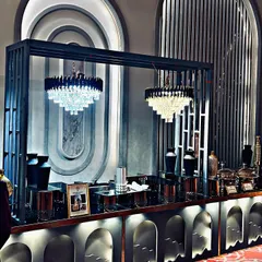 This art-deco inspired buffet station was designed for a sophisticated corporate gala. The custom framework, integrated chandeliers, and sleek black serveware create a dramatic and stylish focal point for the dining area.