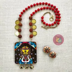 Feel the power of the goddess with this Durga necklace set. I painted this piece to be bold and protective, using a strong red and yellow palette. The set includes a detailed MDF pendant with brass ghungroos, wooden jhumkas, and sacred rudraksha beads.