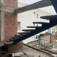 Another angle of the cantilevered metal staircase, showing how it is anchored to the building's structure to create a "floating" effect.
