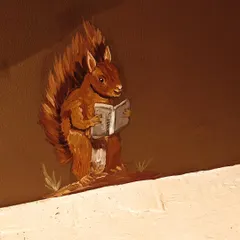 A close-up of a clever little squirrel reading a book, a charming detail from a whimsical wildlife mural I painted for a kid's room in Delhi.