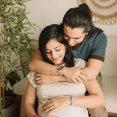 A sweet moment between the expecting couple. Her makeup is soft and romantic, perfect for this intimate photoshoot.