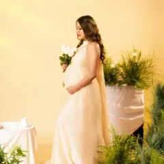 A side profile from the same dreamy, light-filled set, showcasing the beautiful silhouette of the baby bump.