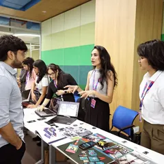 I enjoy helping the next generation of artists find their footing. In this photo, I'm reviewing a student's portfolio at Atlas Skilltech University, offering feedback to help them connect their creative projects with real-world industry expectations.