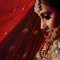 The true beauty of a bride lies in the eyes of the groom. This close up shot, with the red dupatta creating a soft frame, highlights her delicate features and bridal glow.