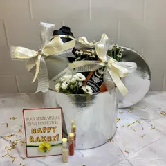 A sleek and modern Rakhi hamper in a silver box. This gift set includes a shaker bottle and coffee, perfect for a fitness-loving brother, complete with a 'Happy Rakhi' card and traditional elements.