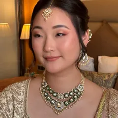 I believe in enhancing, not transforming. For this beautiful bride, I used soft pink and peach tones on the eyes and cheeks to complement her East Asian features and ivory lehenga, creating a fresh and radiant pre-wedding look.