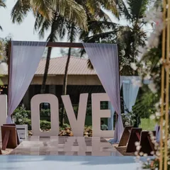A bold statement for a beach wedding. This large "LOVE" sign at the start of the aisle is a fantastic photo opportunity and sets a romantic tone for the ceremony.