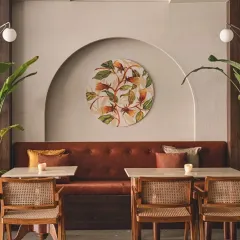 In our Bali-themed cafe, we used soft arched niches to create intimate seating nooks. Each niche is highlighted with hand-painted art, complemented by rattan chairs and terracotta upholstery to achieve a rustic yet contemporary balance.