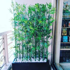 A dense arrangement of artificial bamboo in a rectangular planter. This works great as a natural-looking screen for a balcony or to divide a room.