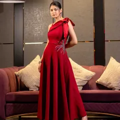 A powerful, stationary pose in a striking red one-shoulder gown. This image focuses on the dress's structure, color, and the unique bow detail, conveying pure elegance.