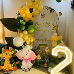 My jungle theme setups are a big hit with the kids. This one features cute elephant and giraffe cutouts, a personalized backdrop, and a big light-up number '2' for the birthday boy.