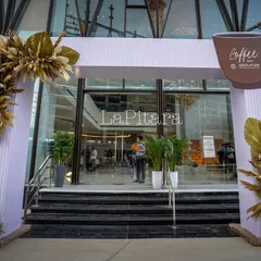 A straight-on view of the entrance arch, featuring a custom-cut logo of a coffee cup. Every detail, from the signage to the floral decor, is planned to reinforce the event's theme.