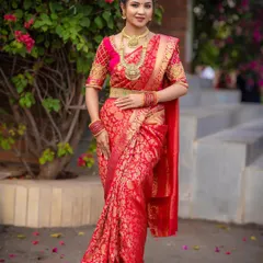 A stunning South Indian bridal look created for a photoshoot. The model is wearing a rich red Kanjivaram saree with traditional temple jewellery.