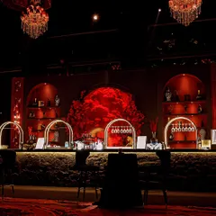 A stunning bar setup for the "Red Royal Affair." The arched back-bar, filled with a mass of red roses and illuminated to create a powerful focal point, served as the heart of the party.