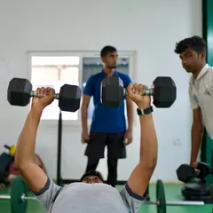 Strength and conditioning are key. A player performs a dumbbell bench press under the watchful eye of our fitness coaches from YOS Sports Health Specialists.
