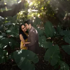 A tender moment shared amidst the foliage of a dense forest. The dappled sunlight filtering through the leaves adds a touch of magic to this candid pre-wedding shot.