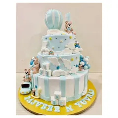 Another view of the charming three-tiered teddy bear cake, featuring a hot air balloon topper and cute ABC blocks for a classic first birthday theme.