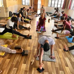 A class of aspiring yoga teachers works on splits and hip openers. Our YTTC is intensive, building strength and flexibility in our students. A new batch starts soon!