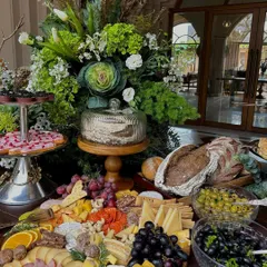 An angle highlighting the abundance of the spread, from fresh grapes and charcuterie to artisanal breads and pastries.