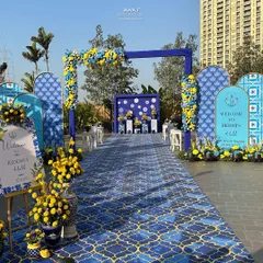 A vibrant and joyful Haldi ceremony entrance, featuring a stunning blue and yellow Moroccan tile theme, complete with floral arches and personalized welcome signs to celebrate your pre-wedding festivities in style.