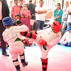 A young student demonstrates focus and power, executing a precise kick during a kumite match. This is what our competition coaching is all about: building the skill and confidence to perform under pressure.