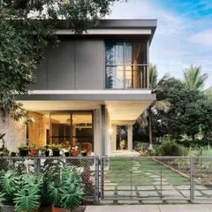 "Casa Magnifera" is a study in modern tropical architecture. The design features a simple cubic form with a cantilevered upper level, using a palette of grey cement board and exposed concrete to blend with the lush green surroundings.