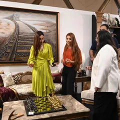 A candid moment from the IADS event, where attendees were drawn to the captivating collection. I love sharing the stories behind each piece, like this elegant chess set on the marble coffee table.