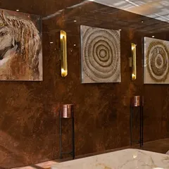 An art wall in the hotel lobby. I curated a series of abstract and textured artworks, complemented by elegant brass wall sconces, to create a gallery-like feel.