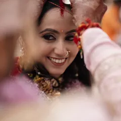 A close-up, intimate moment during the sindoor daan ceremony. The bride's joyful smile as the sindoor is applied is a powerful symbol of her marital union.