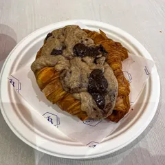 A close-up of the Crookie, showing the texture of the flaky croissant and the generous amount of chocolate chip cookie dough baked right on top.
