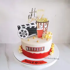 A fun Netflix themed cake for a movie lover's birthday. This design features a movie clapperboard, popcorn, and the Netflix logo, perfect for a "Netflix and chill" party.