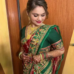 A close-up of the client's makeup, showing the soft eye makeup and the beautiful red lip that complements her traditional attire.