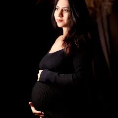 A classic, artistic maternity portrait that celebrates the quiet strength and beauty of motherhood. This is a sample of our fine art studio work, focusing on dramatic lighting and emotion.